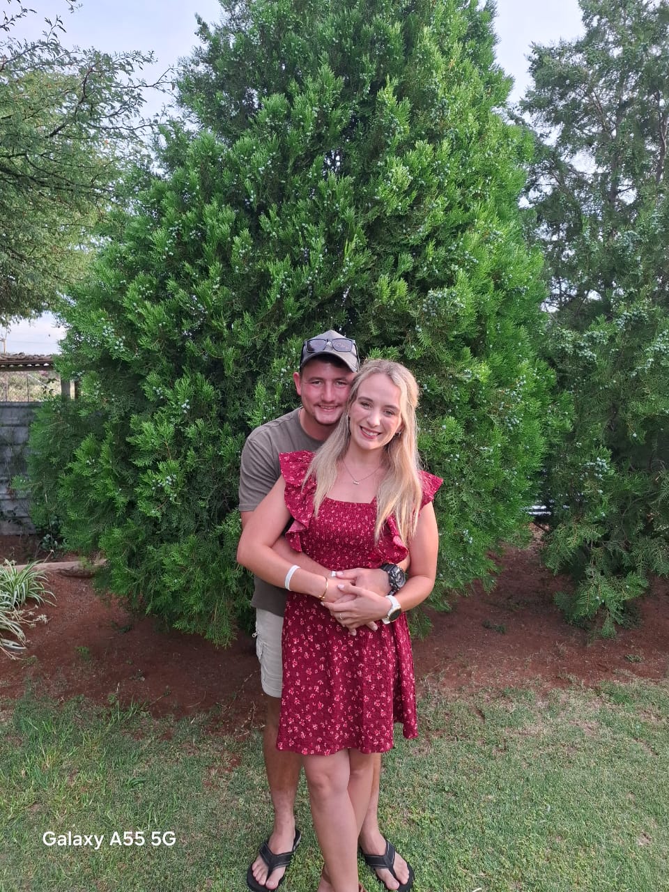 Gerhardt holding Michelle in front of a tree